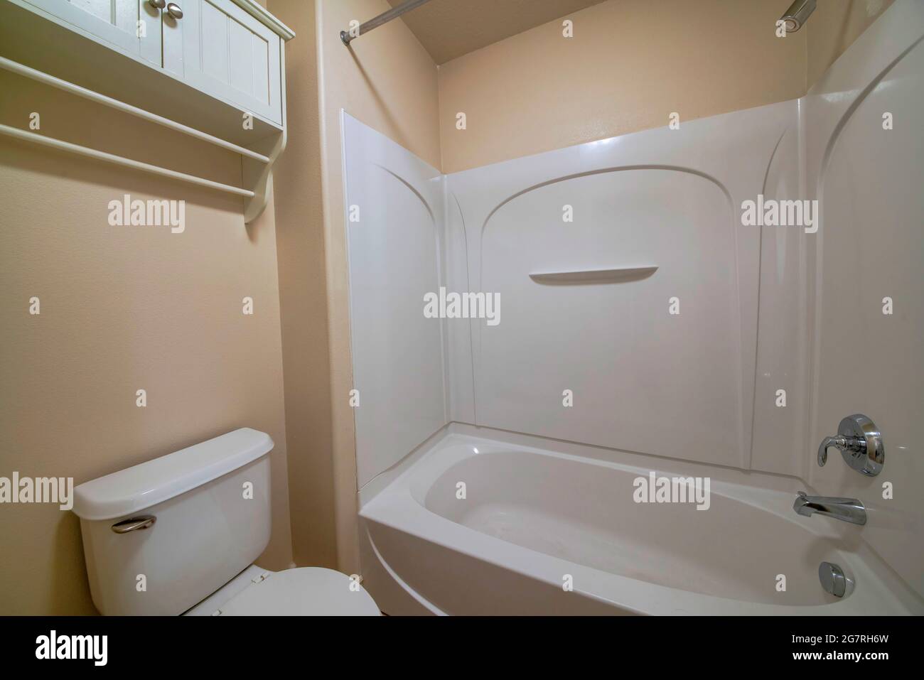 Interno di un piccolo bagno con pareti color crema Foto Stock