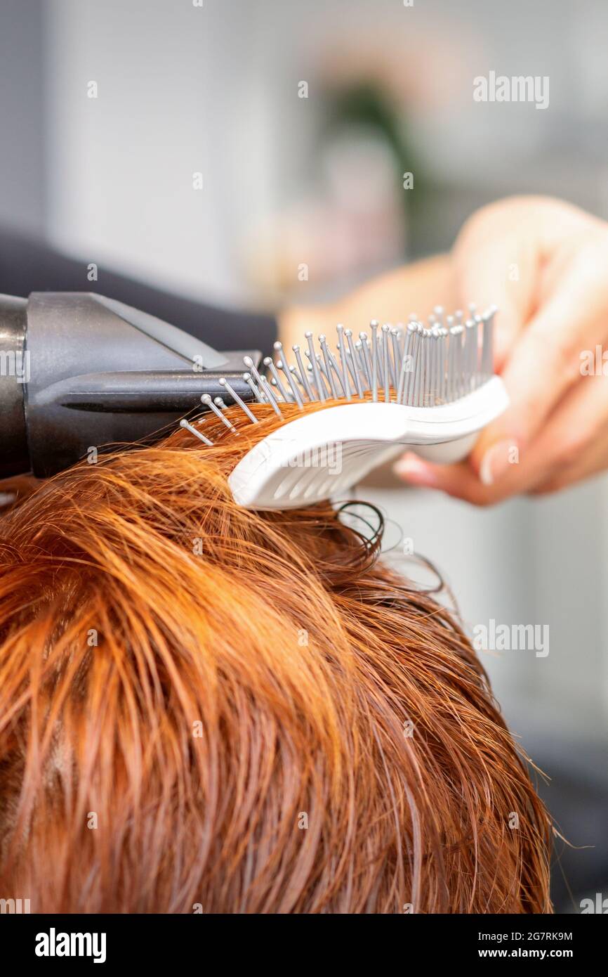 Closeup della mano del padrone con l'aria-asciugando e la spazzola che soffia i capelli rossi femminili in un salone Foto stock - Alamy Closeup della mano del padrone con l'aria-asciugando e la spazzola che soffia i capelli rossi femminili in un salone Foto stock - Alamy