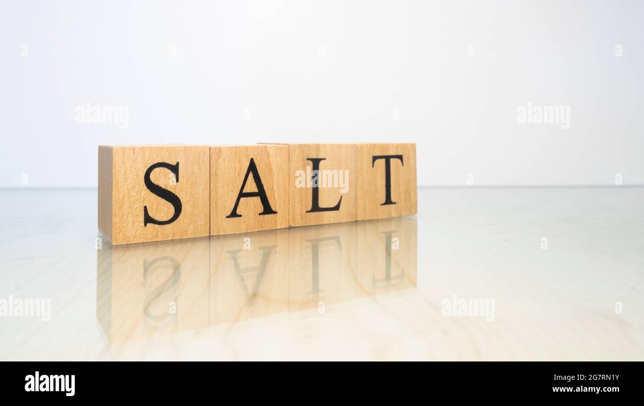La parola sale è stata creata da cubetti di lettere di legno. Gastronomia e spezie. Primo piano. Foto Stock