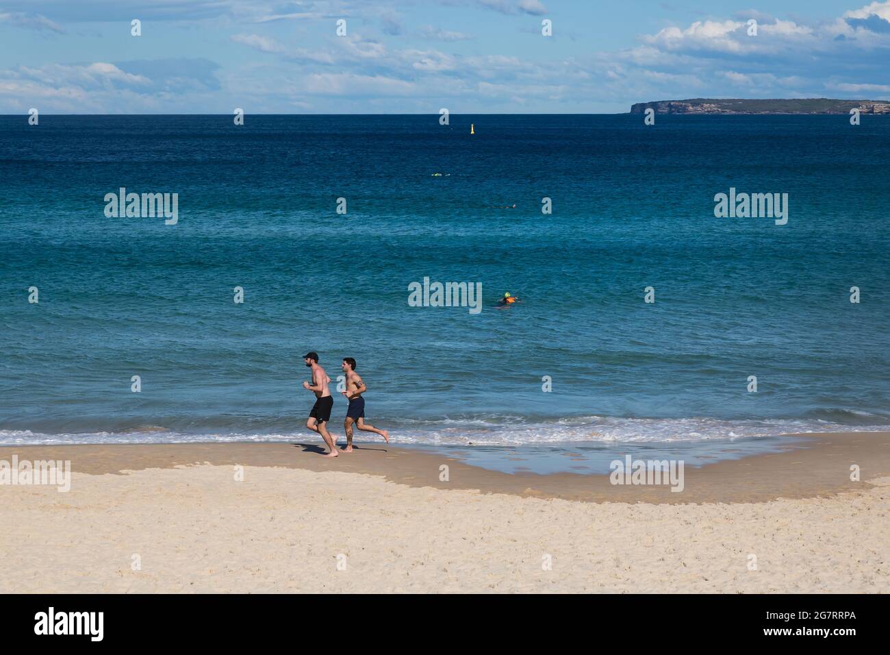 Sydney, Australia. Venerdì 16 luglio 2021. Le persone formano Bondi visto jogging lungo Bondi Beach. Le restrizioni di blocco sono state rafforzate ed estese a causa della variante Delta dei casi COVID-19 in tutta Sydney, le Blue Mountains e l'area della Central Coast. L'esercizio è limitato a due persone per gruppo e le persone devono remian entro un raggio di 10 km dalla loro casa. Credit: Paul Lovelace/Alamy Live News Foto Stock