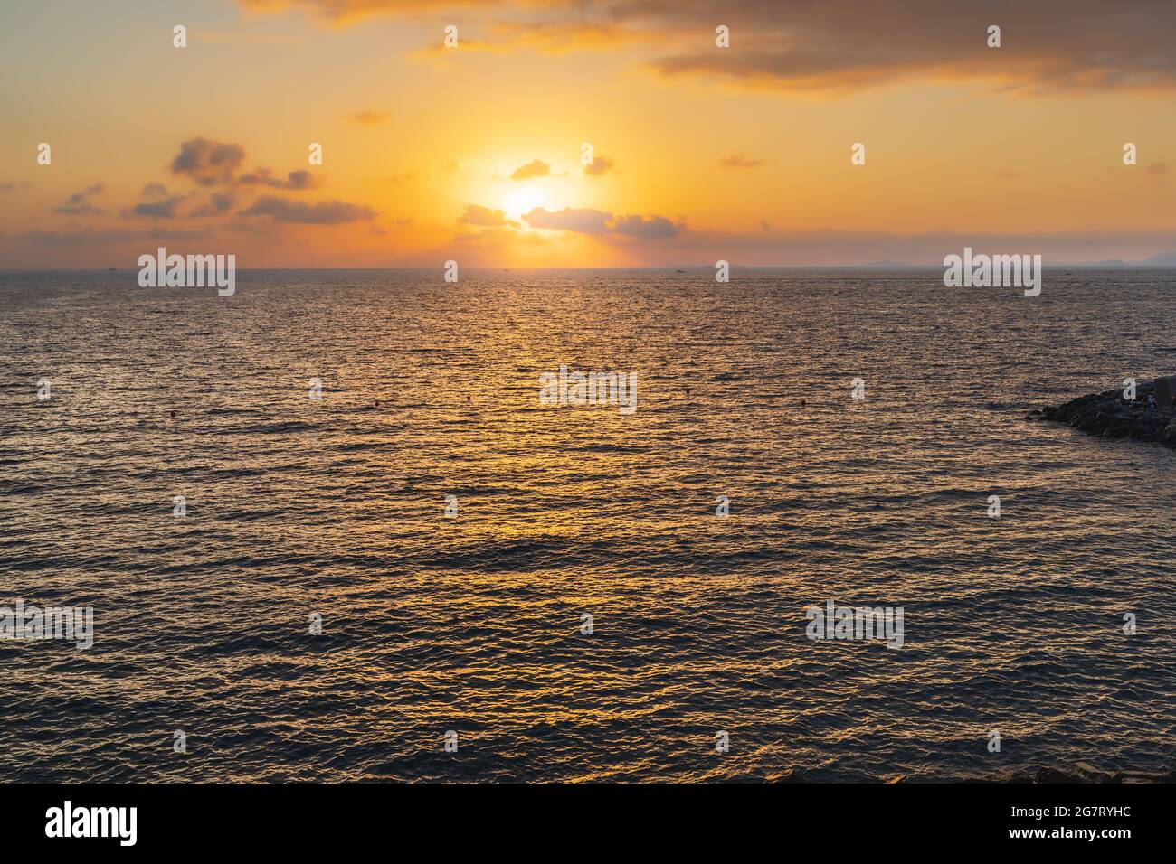 Splendido tramonto sul mare con sole dietro le nuvole Foto Stock