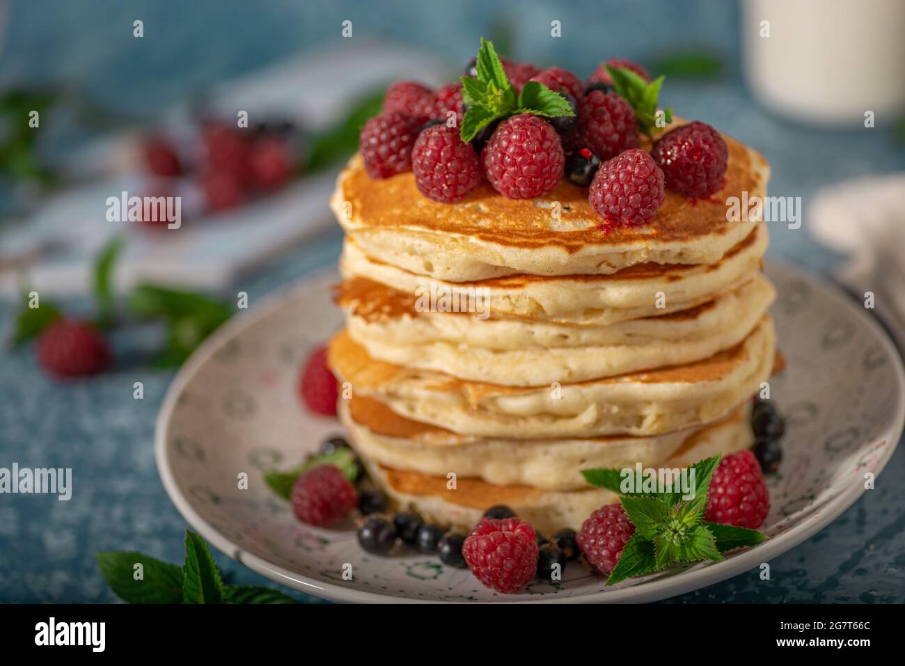 Deliziose frittelle soffici con frutti di bosco e sciroppo d'acero Foto Stock