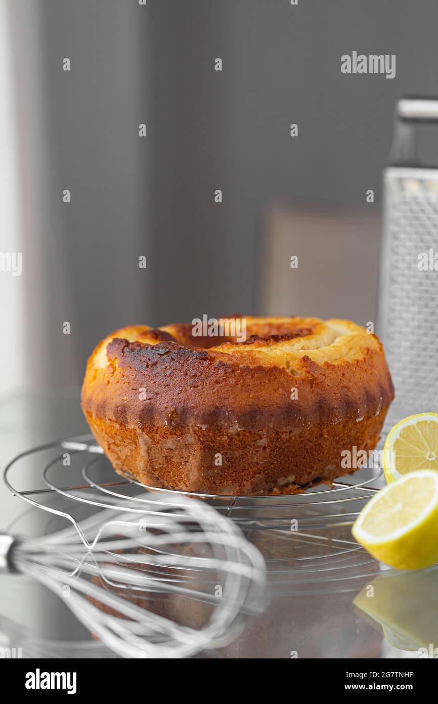 Torta al limone fatta in casa sulla griglia con un grattugia di whisk e limoni. Ricetta di cottura Foto Stock