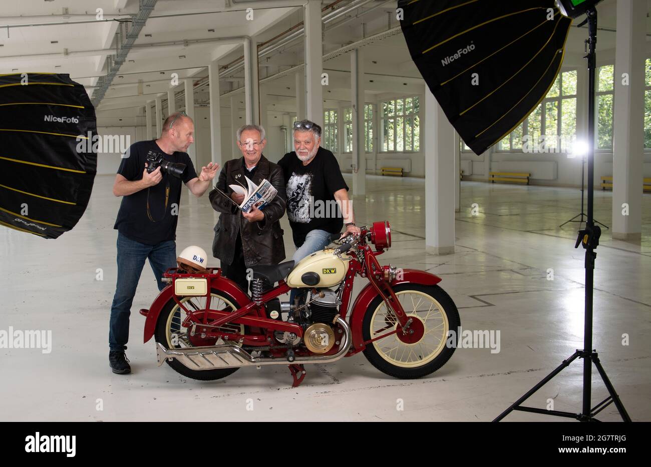 Zschopau, Germania. Luglio 16 2021: Il fotografo Detlev Müller (l-r) istruisce Reiner Mattheß, proprietario del DKW Luxus 500, e l'esperto DKW Frieder Bach negli ex centri di produzione del DKW e MZ a Zschopau. In occasione del 100° anniversario della produzione motociclistica a Zschopau nel 2022, Bach sta lavorando ad un nuovo lavoro standard su tutte le motociclette della serie DKW. La prima moto ha fatto il suo ingresso nella linea di produzione nel 1922. Da oggi, Zschopau ha portato il titolo di 'Motorcycle City'. Credit: dpa Picture Alliance/Alamy Live News Foto Stock