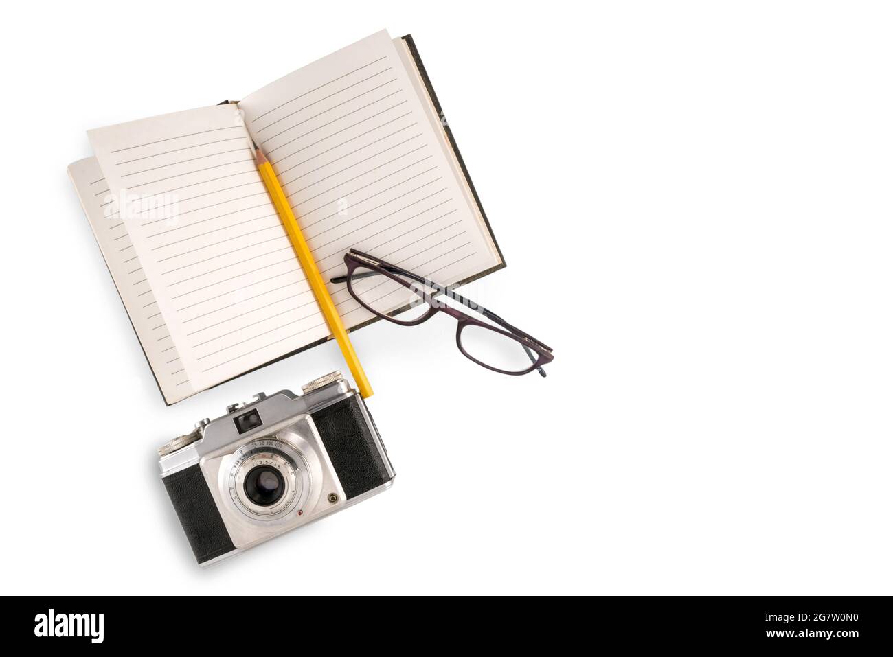 Fotocamera retrò con notebook foderato e matita gialla e occhiali isolati su bianco, concetto di viaggio, spazio di copia Foto Stock Fotocamera retrò con notebook foderato e matita gialla e occhiali isolati su bianco, concetto di viaggio, spazio di copia Foto Stock