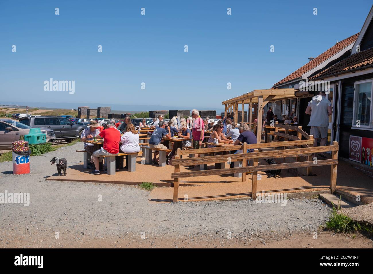 Una vista del ristorante locale Fish and chip a Dunwich Beach con molte persone sedute all'aperto che mangiano e bevono in una soleggiata giornata estiva Foto Stock
