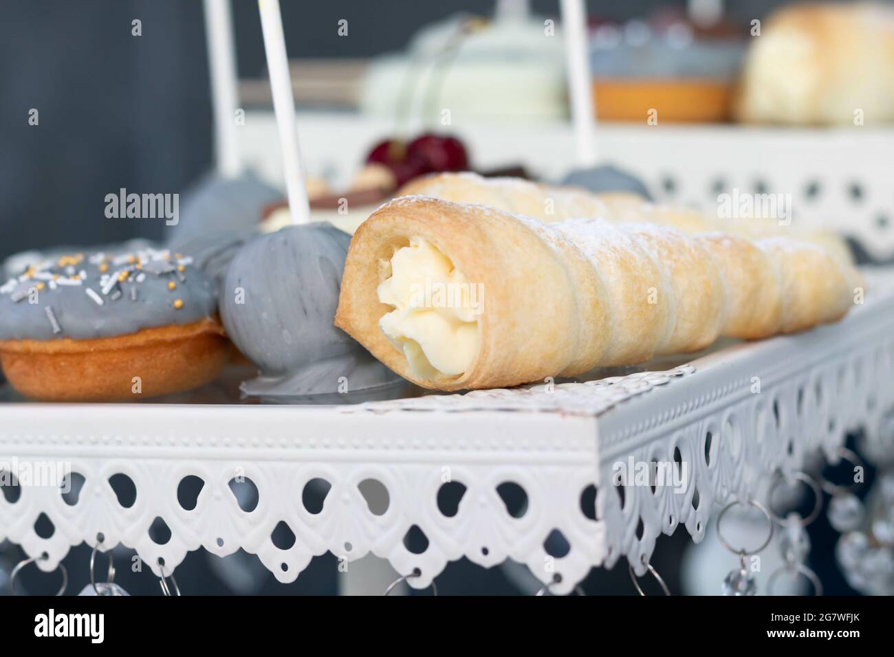 Fuoco selettivo di deliziosi papi torta, cono tubo con crema di ripieno, e una ciambella Foto Stock