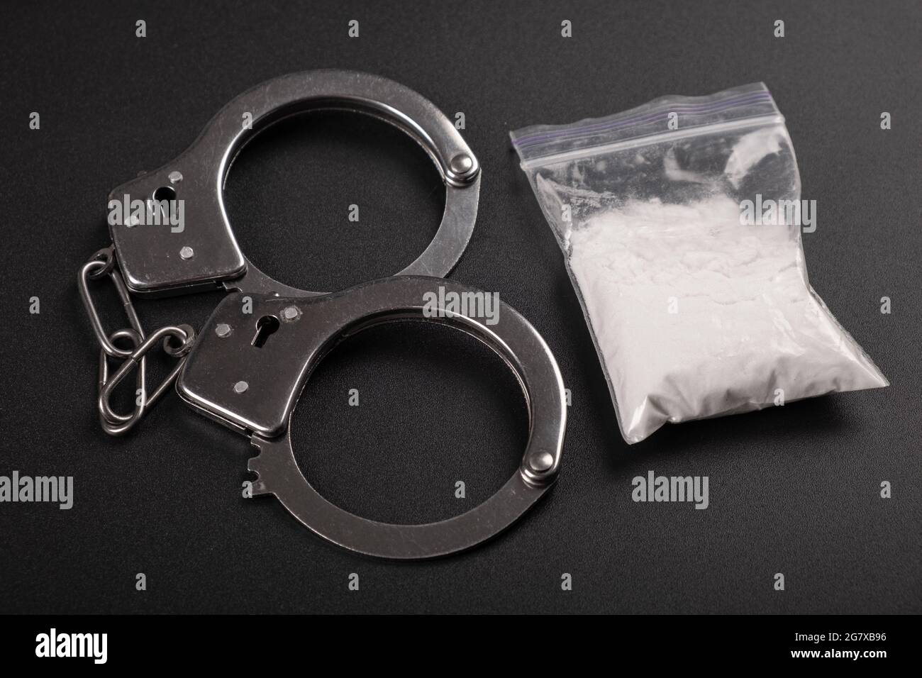 vista dall'alto della punizione farmacologica, manette e polvere di cocaina bianca. Foto Stock