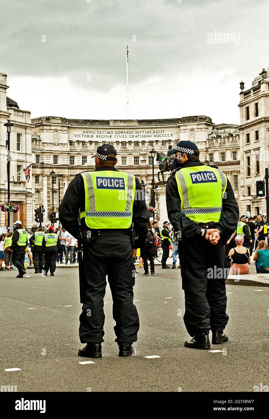 Gli ufficiali di polizia guardano una manifestazione di protesta a Londra Foto Stock