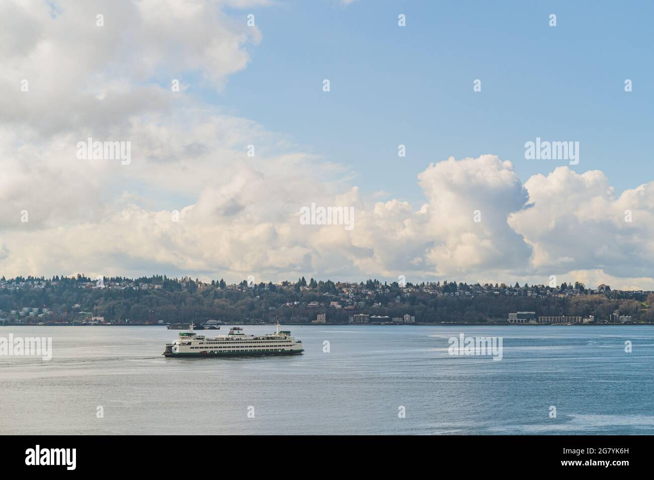 Washington Ferry naviga su Elliot Bay con West Seattle e Cloud Sky background Foto Stock