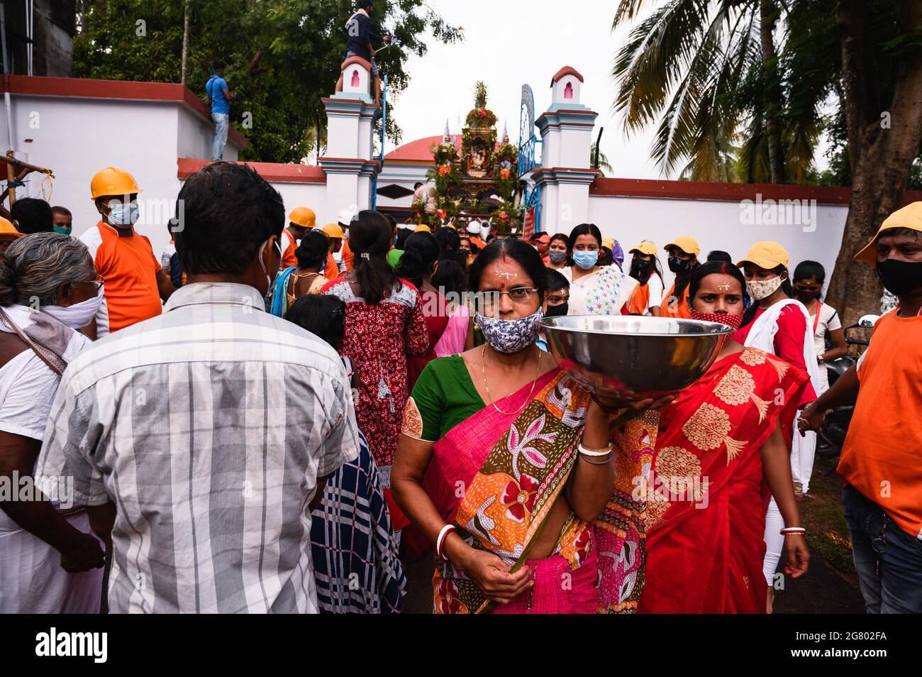 La festa di Ratha Yatra è stata celebrata all'interno del tempio di Tehatta, in conformità con le norme amministrative per le precauzioni contro il coronavirus. Non è stato permesso loro di entrare senza maschere. Un'organizzazione volontaria ha aiutato con l'igienizzatore per i devoti. Anche se ci erano regole, alcuni bambini ed anziani non hanno indossato le maschere o non stavano indossando le maschere correttamente. Tehatta, Bengala Occidentale; India. Foto Stock