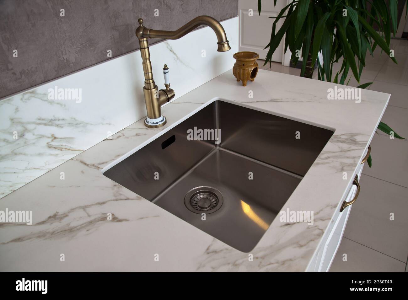 Interni di lussuosa cucina moderna e lavello e rubinetto in acciaio inox Foto Stock