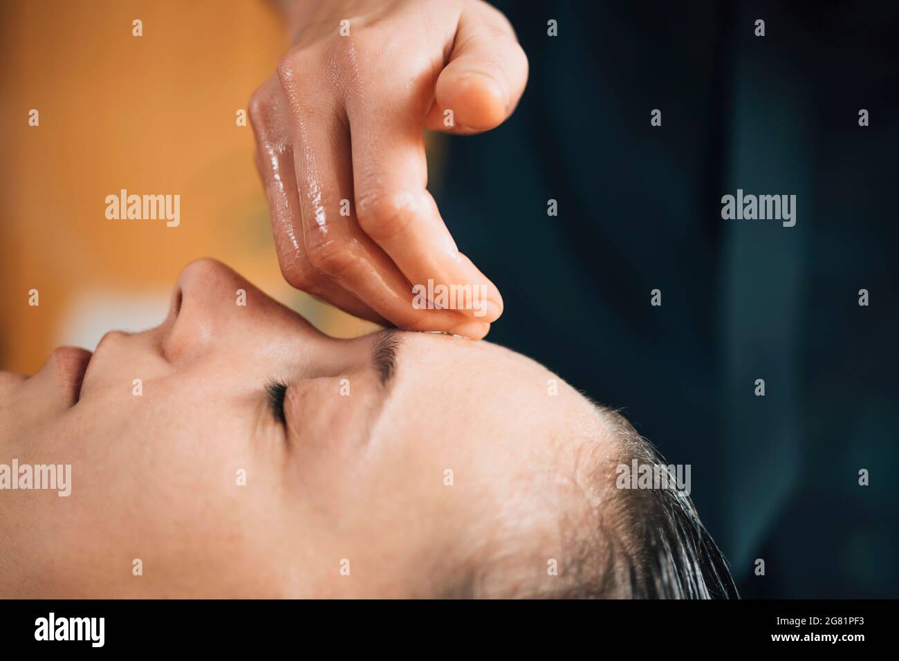 Massaggio ayurvedico alla fronte con olio essenziale Foto Stock