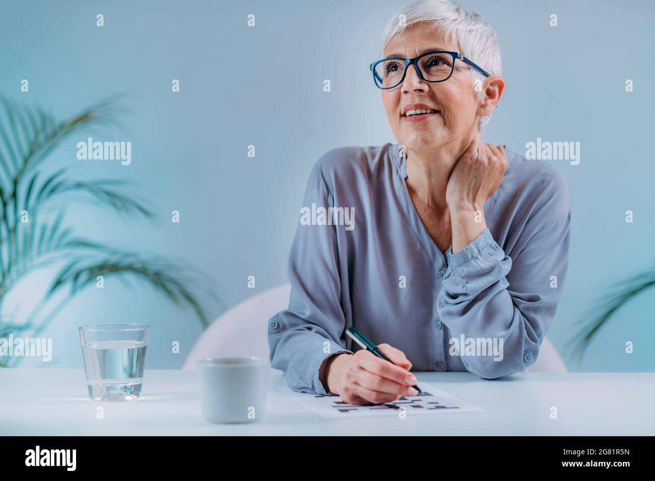 Donna anziana che risolve il puzzle crossword Foto Stock