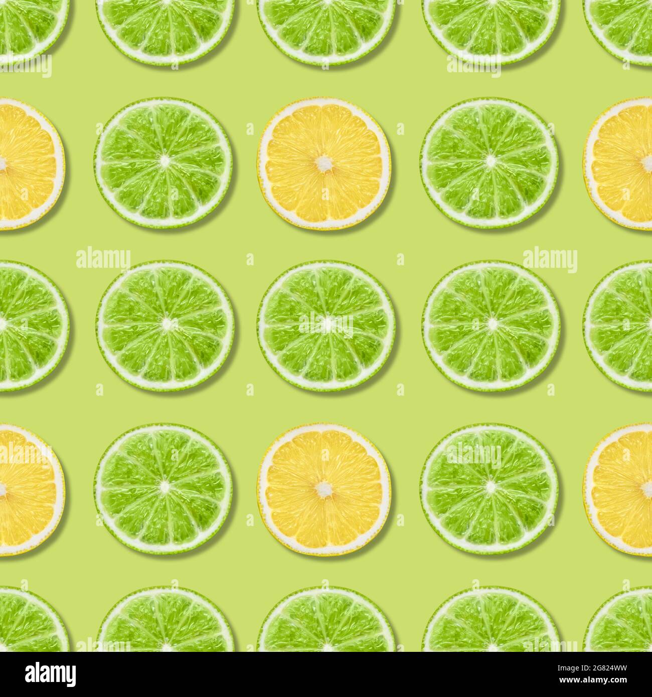 Motivo senza cuciture con lime e limone su sfondo verde. Sfondo astratto tropicale. Frutta estate modello. Vista dall'alto, disposizione piatta. Foto Stock