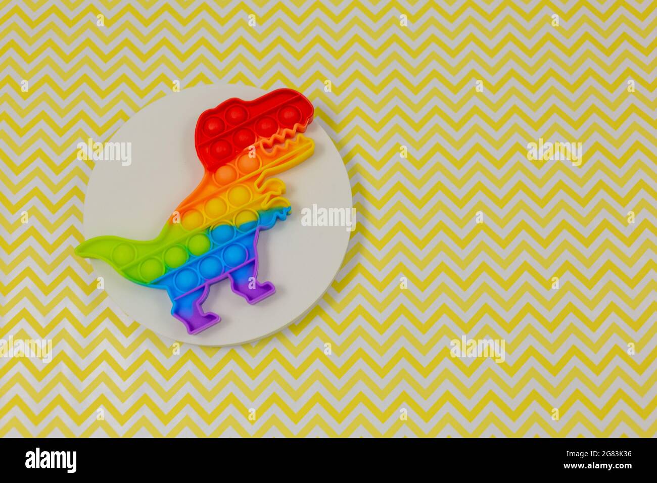 Popolari giocattoli in silicone anti-stress pop-it per un bambino su sfondo giallo. Trendy reliever stress sensoriale Fidget Toy per bambini e adulti Foto Stock
