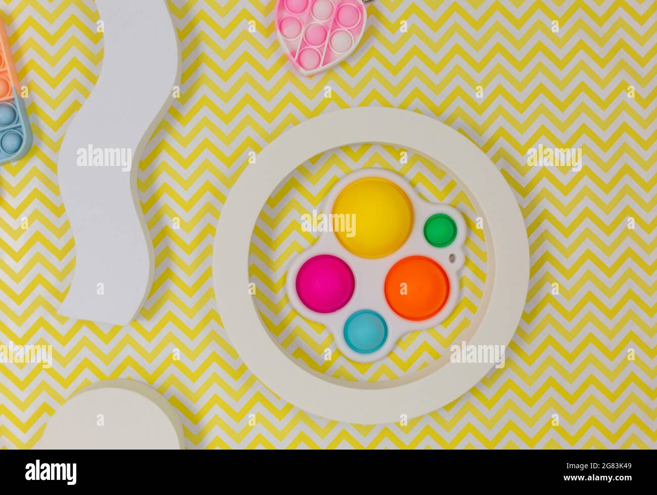 Popolari giocattoli in silicone anti-stress pop-it per un bambino su sfondo giallo. Trendy reliever stress sensoriale Fidget Toy per bambini e adulti Foto Stock