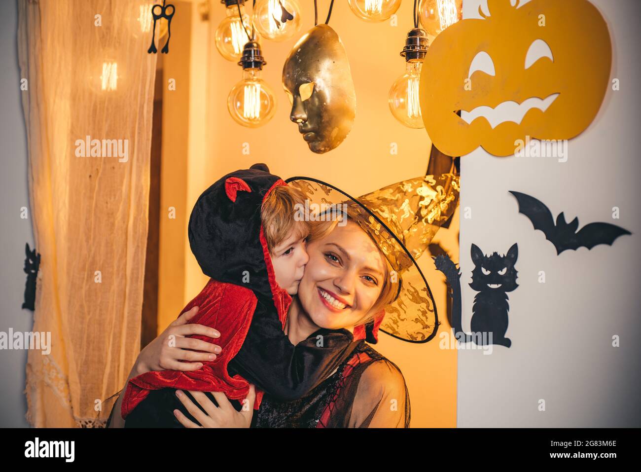 Halloween abiti su madre e figlio e strega costumi e cappelli strega. La caramella più popolare per Halloween. Halloween testa di zucca jack lanterna con Foto Stock