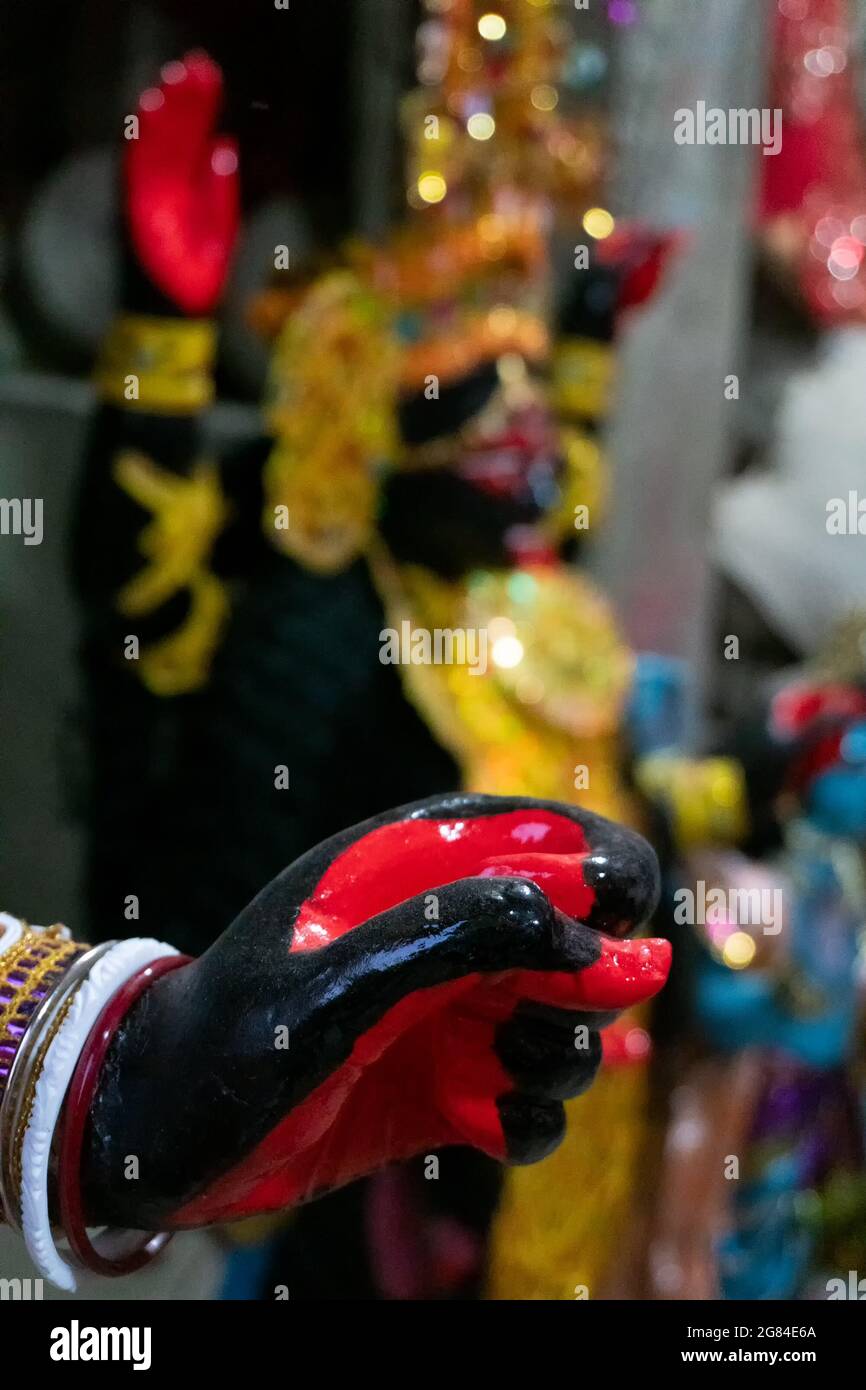Kolkata, Bengala Occidentale, India - 7 Ottobre 2018 : mano dipinta della Dea Kali, idolo sfocato sullo sfondo. Dea del tempo, della creazione, della distruzione e. Foto Stock