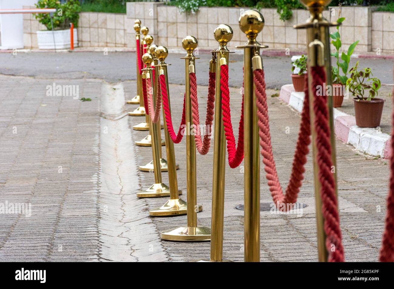 Primo piano di barriere dorate con corda rossa. Foto Stock