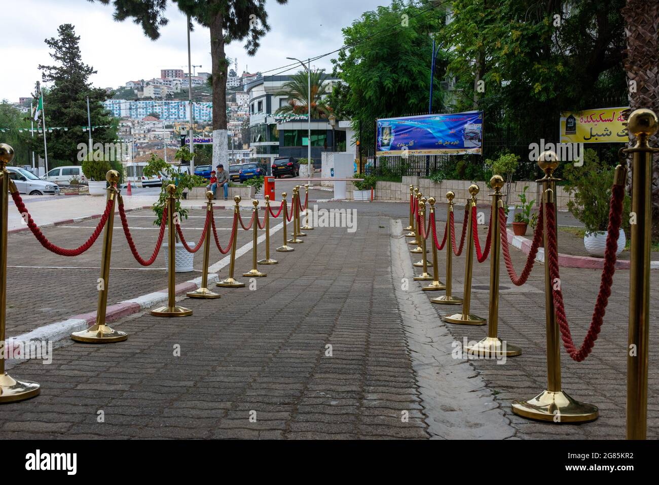 Due linee di barriere dorate con corda rossa. Foto Stock