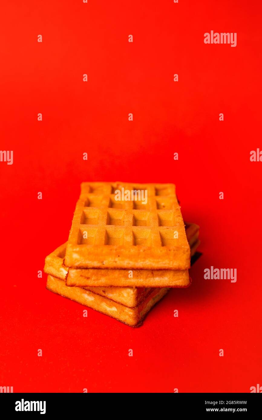 waffle freschi con ripieno su sfondo rosso. Foto Stock