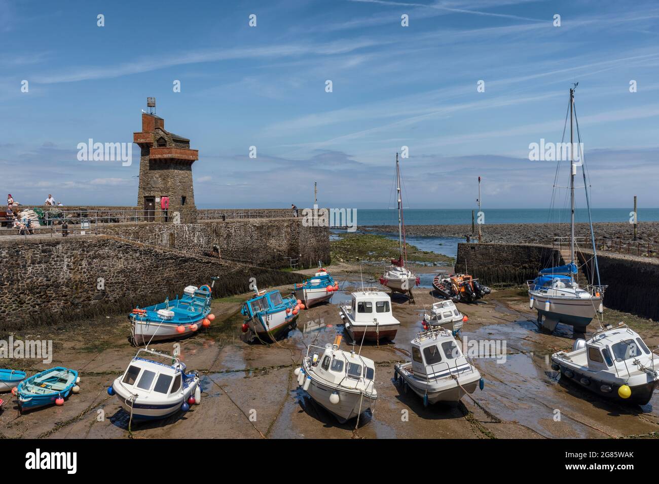 Marea fuori e le barche ormeggiate nel porto di Lynmouth con la storica Rhenish Tower sul molo. Exmoor National Park, Devon, Inghilterra, Regno Unito Foto Stock
