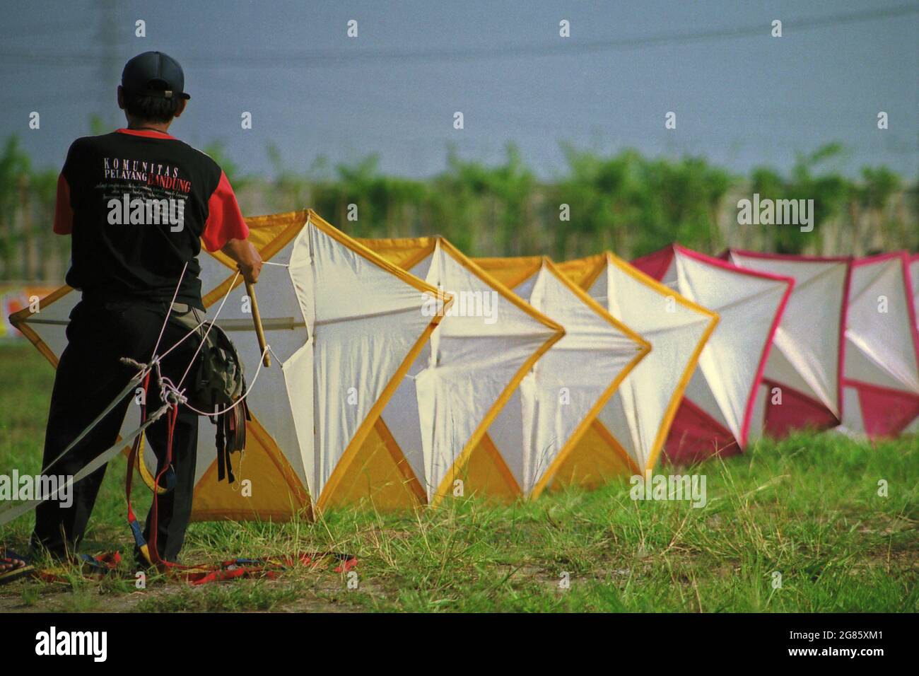 Un uomo che prepara un aquilone gigante durante il Festival Internazionale del Kite di Giacarta del 2004 che si è tenuto il 9-11 luglio a Carnival Beach ad Ancol Dreamland, Jakarta Nord, Giacarta, Indonesia. Foto Stock