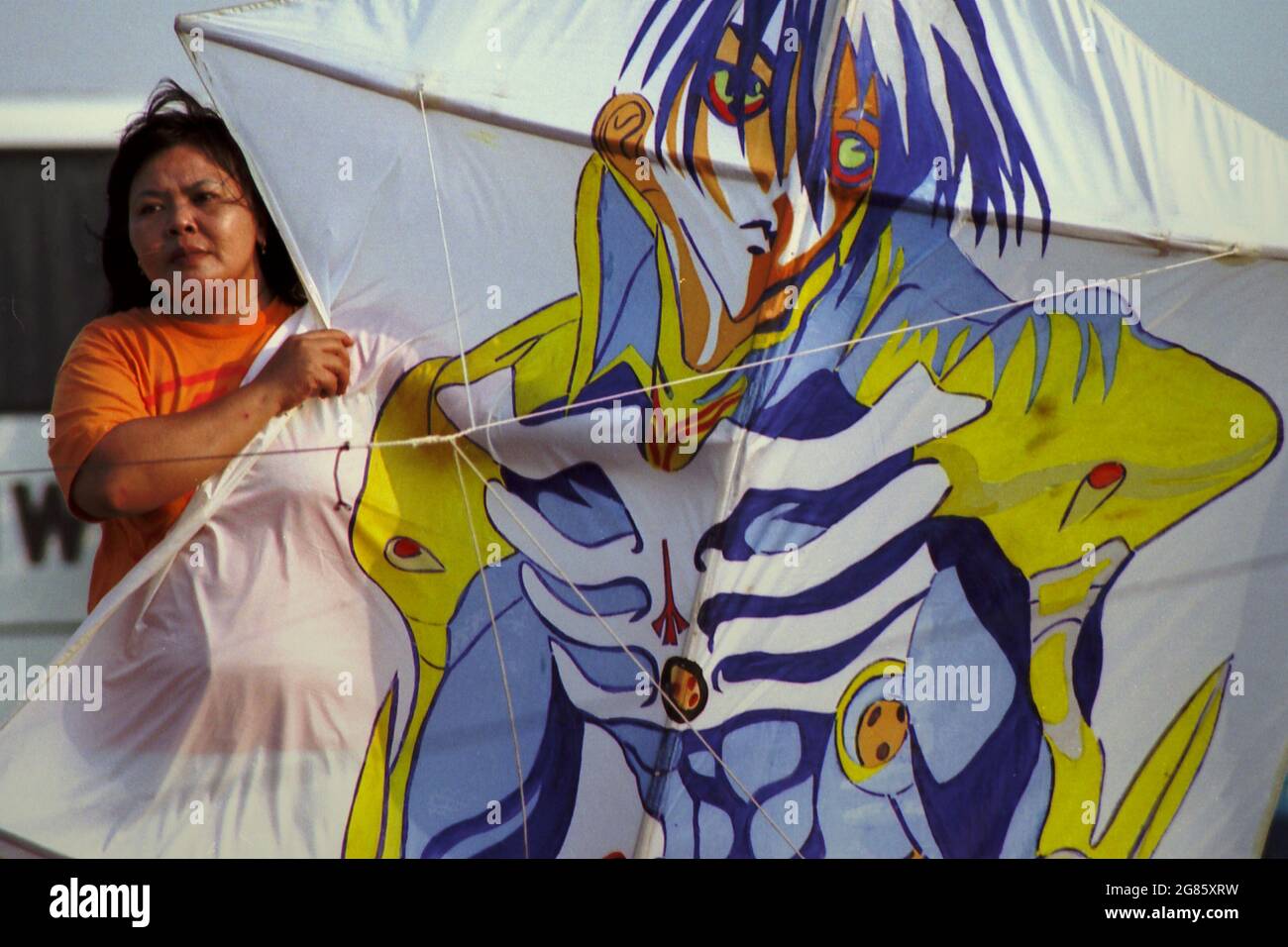 Una donna che tiene un aquilone durante il Festival Internazionale del Kite di Giacarta del 2004 che si è tenuto il 9-11 luglio a Carnival Beach ad Ancol Dreamland, Jakarta Nord, Jakarta, Indonesia. Foto Stock