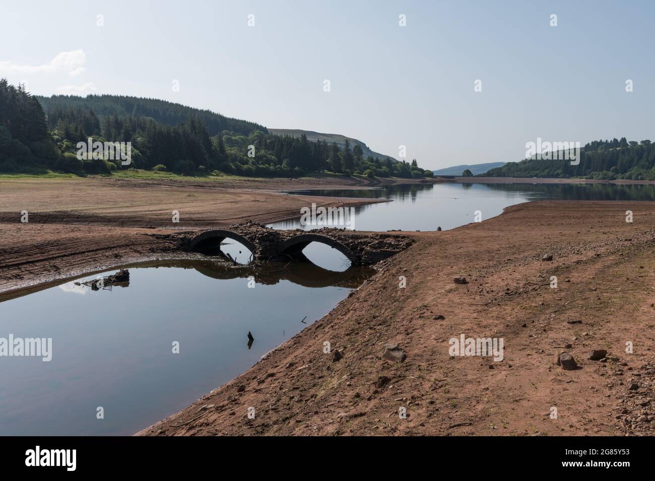 Llwyn Onn Reservoir, Merthyr Tydfil, Galles del Sud, Regno Unito. 17 luglio 2021. Tempo nel Regno Unito: Il tempo caldo continuato ha abbassato i livelli dell'acqua in questo serbatoio e scoperto Pont Yr Ponte DAF, normalmente sott'acqua. Il ponte era in uso prima della costruzione del serbatoio. Credit: Andrew Bartlett/Alamy Live News Foto Stock