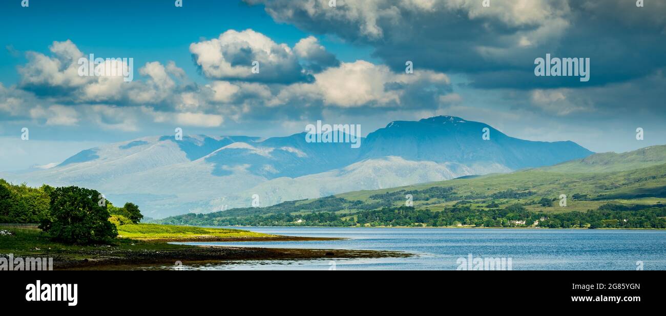 un grande corpo d'acqua con una montagna sullo sfondo. (Ben Nevis i Monti Grampian nella regione delle Highlands di Lochaber) Foto Stock