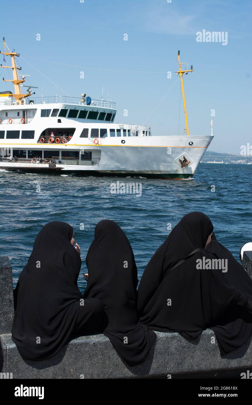 Hijabi donne sulla baia con un bellissimo yacht sull'oceano Foto Stock