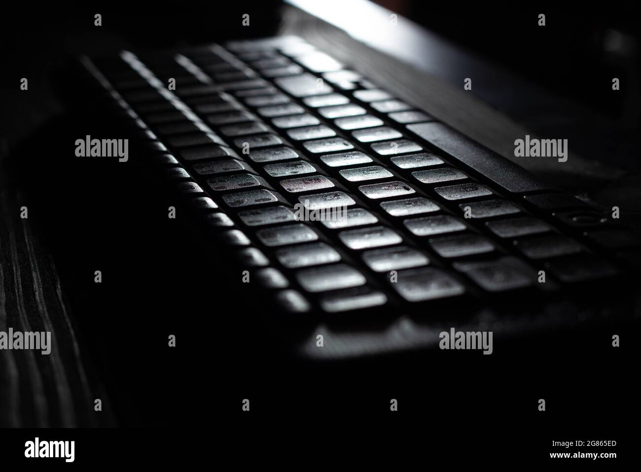 Tastiera senza fili per computer con tasti alfanumerici di controllo, funzione e navigazione e tastierino numerico su sfondo di tavolo in legno sull'ufficio lunare Foto Stock