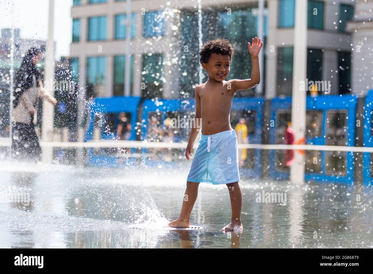 Birmingham, Regno Unito. 17 luglio 2021. Noah, di cinque anni, ha un tempo di spruzzi nelle fontane della piazza del Centenario di Birmingham. Peter Lopeman/Alamy Live News Foto Stock