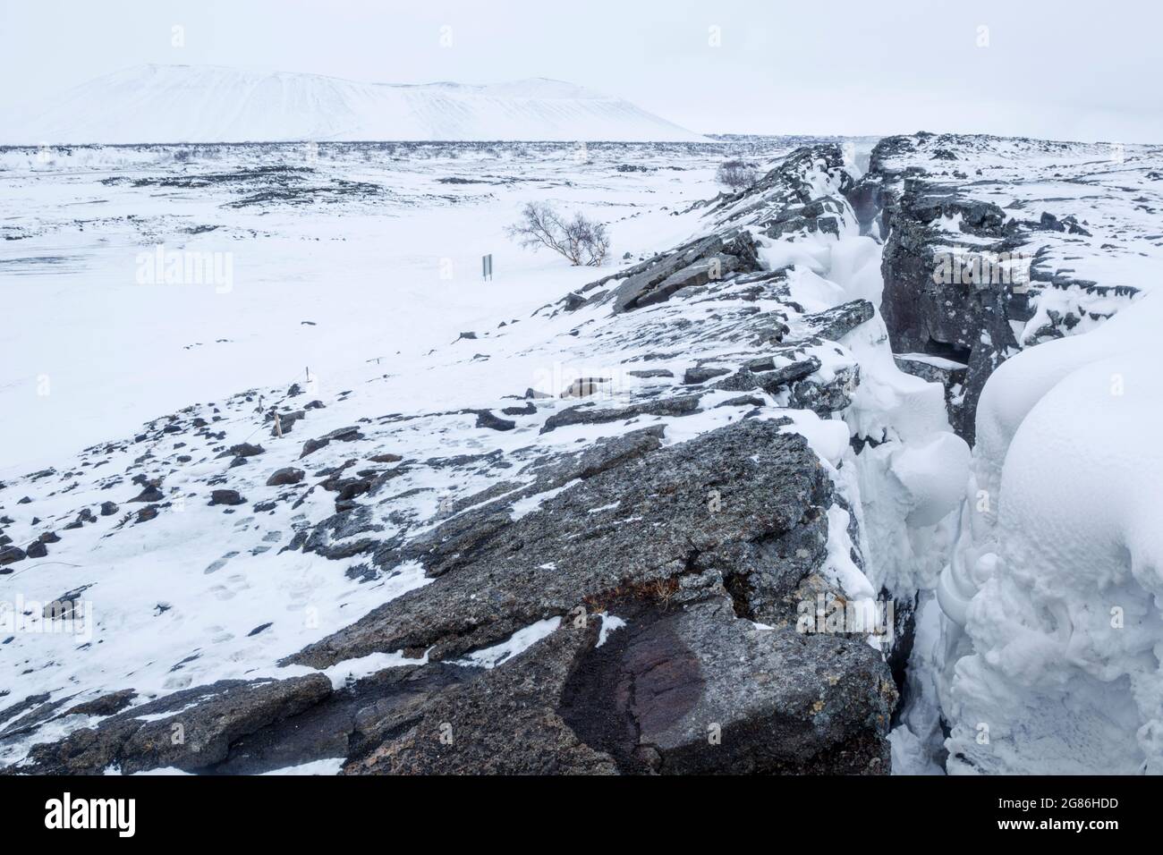 Vista invernale della fessura vulcanica di Grjótagjá vicino al vulcano Hverfjall nel nord dell'Islanda, vicino al lago Myvatn, che ha una bella geotermica caldo spr Foto Stock