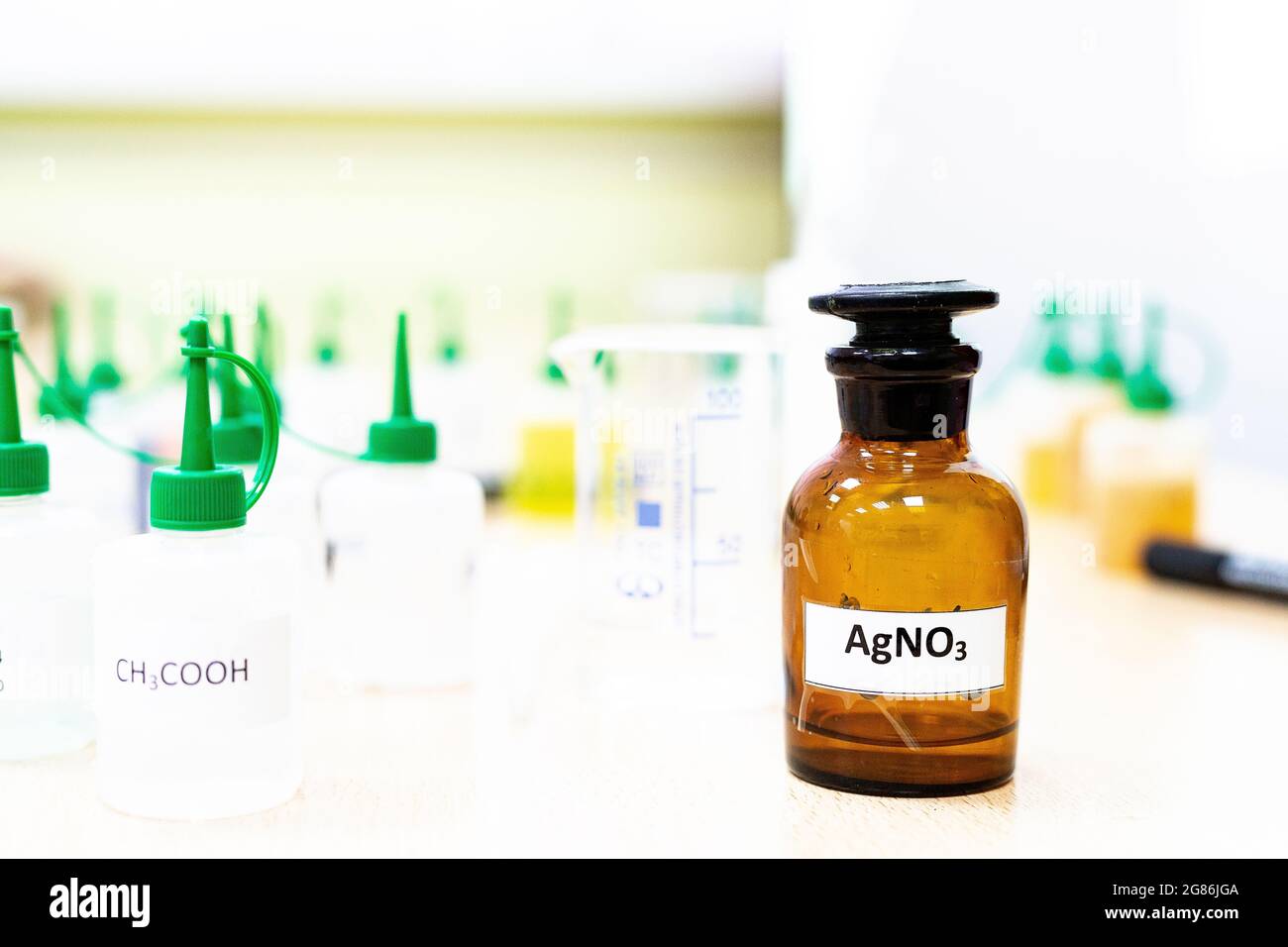 I matracci per l'industria chimica con provette da laboratorio liquide sono riportati sul tavolo nel laboratorio di analisi dei liquidi sviluppo di sostanze di prova veleni Foto Stock
