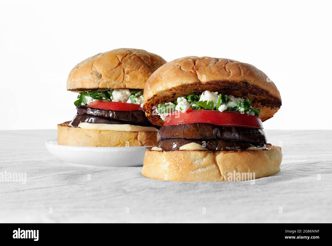 Hamburger con panino vegano con melanzane arrostite, formaggio feta e coriandolo. Concetto di cibo basato su piante Foto Stock
