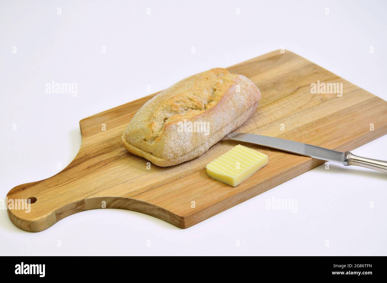 rotolo di pane e burro sul tagliere, primo piano, isolato su backbround bianco Foto Stock