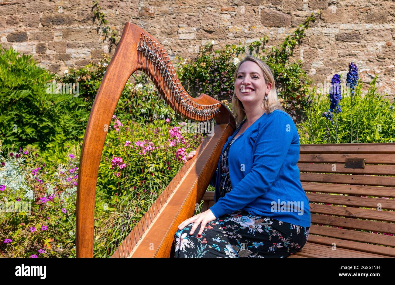 Haddington, East Lothian, Scozia, Regno Unito, 17 luglio 2021. L'arpista celtica Ailie Robertson suona nel giardino murato di Amisfield: Un concerto socialmente distanziato si svolge nel giardino murato gestito da volontari, uno dei più grandi della Scozia. Ailie Robertson è un premiato compositore e performer che suona musica tradizionale e contemporanea arpa Foto Stock