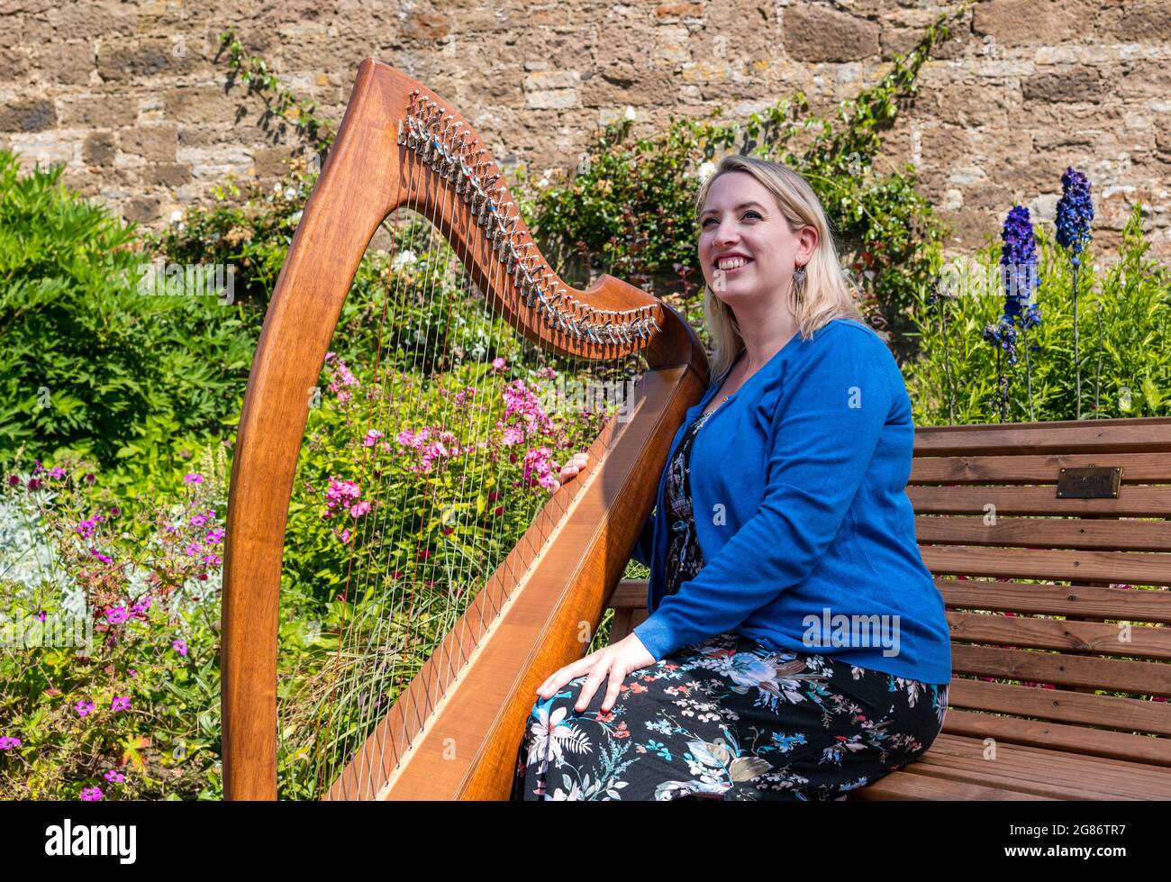 Haddington, East Lothian, Scozia, Regno Unito, 17 luglio 2021. L'arpista celtica Ailie Robertson suona nel giardino murato di Amisfield: Un concerto socialmente distanziato si svolge nel giardino murato gestito da volontari, uno dei più grandi della Scozia. Ailie Robertson è un premiato compositore e performer che suona musica tradizionale e contemporanea arpa Foto Stock