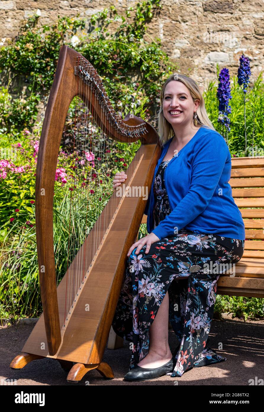 Haddington, East Lothian, Scozia, Regno Unito, 17 luglio 2021. L'arpista celtica Ailie Robertson suona nel giardino murato di Amisfield: Un concerto socialmente distanziato si svolge nel giardino murato gestito da volontari, uno dei più grandi della Scozia. Ailie Robertson è un premiato compositore e performer che suona musica tradizionale e contemporanea arpa Foto Stock