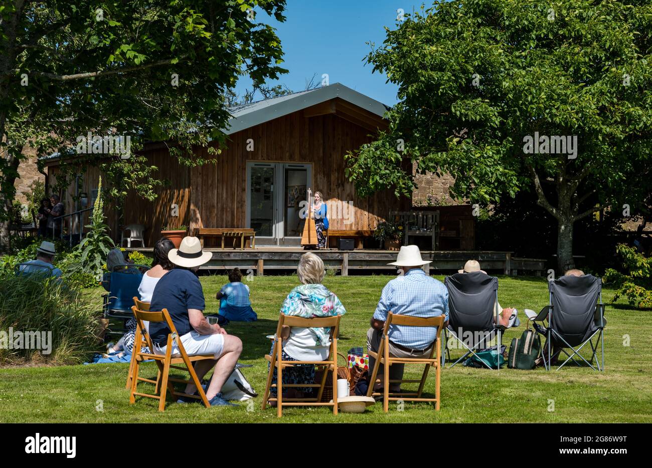 Haddington, East Lothian, Scozia, Regno Unito, 17 luglio 2021. L'arpista celtica Ailie Robertson suona nel giardino murato di Amisfield: Un concerto socialmente distanziato si svolge nel giardino murato gestito da volontari, uno dei più grandi della Scozia. Ailie Robertson è un premiato compositore e performer che suona musica tradizionale e contemporanea arpa Foto Stock