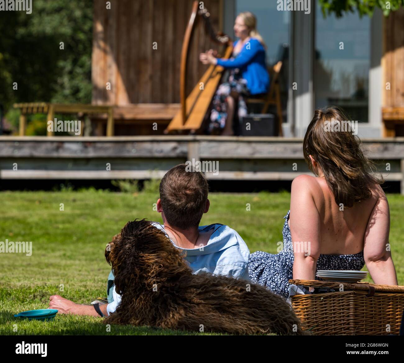 Haddington, East Lothian, Scozia, Regno Unito, 17 luglio 2021. L'arpista celtica Ailie Robertson suona nel giardino murato di Amisfield: Un concerto socialmente distanziato si svolge nel giardino murato gestito da volontari, uno dei più grandi della Scozia. Ailie Robertson è un premiato compositore e performer che suona musica tradizionale e contemporanea arpa Foto Stock