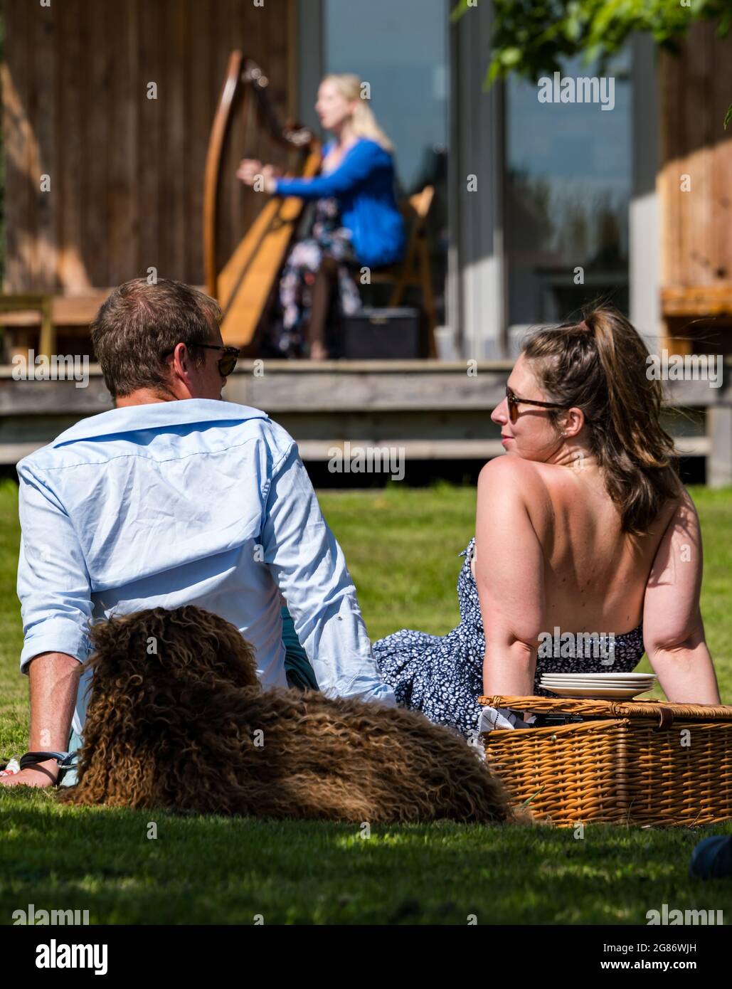 Haddington, East Lothian, Scozia, Regno Unito, 17 luglio 2021. L'arpista celtica Ailie Robertson suona nel giardino murato di Amisfield: Un concerto socialmente distanziato si svolge nel giardino murato gestito da volontari, uno dei più grandi della Scozia. Ailie Robertson è un premiato compositore e performer che suona musica tradizionale e contemporanea arpa Foto Stock