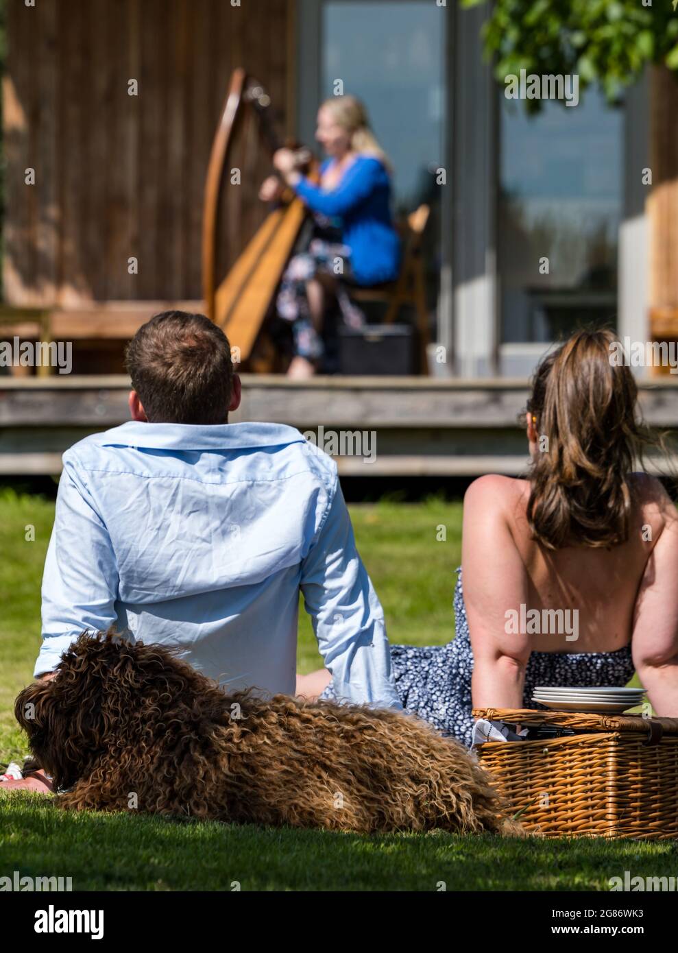 Haddington, East Lothian, Scozia, Regno Unito, 17 luglio 2021. L'arpista celtica Ailie Robertson suona nel giardino murato di Amisfield: Un concerto socialmente distanziato si svolge nel giardino murato gestito da volontari, uno dei più grandi della Scozia. Ailie Robertson è un premiato compositore e performer che suona musica tradizionale e contemporanea arpa Foto Stock