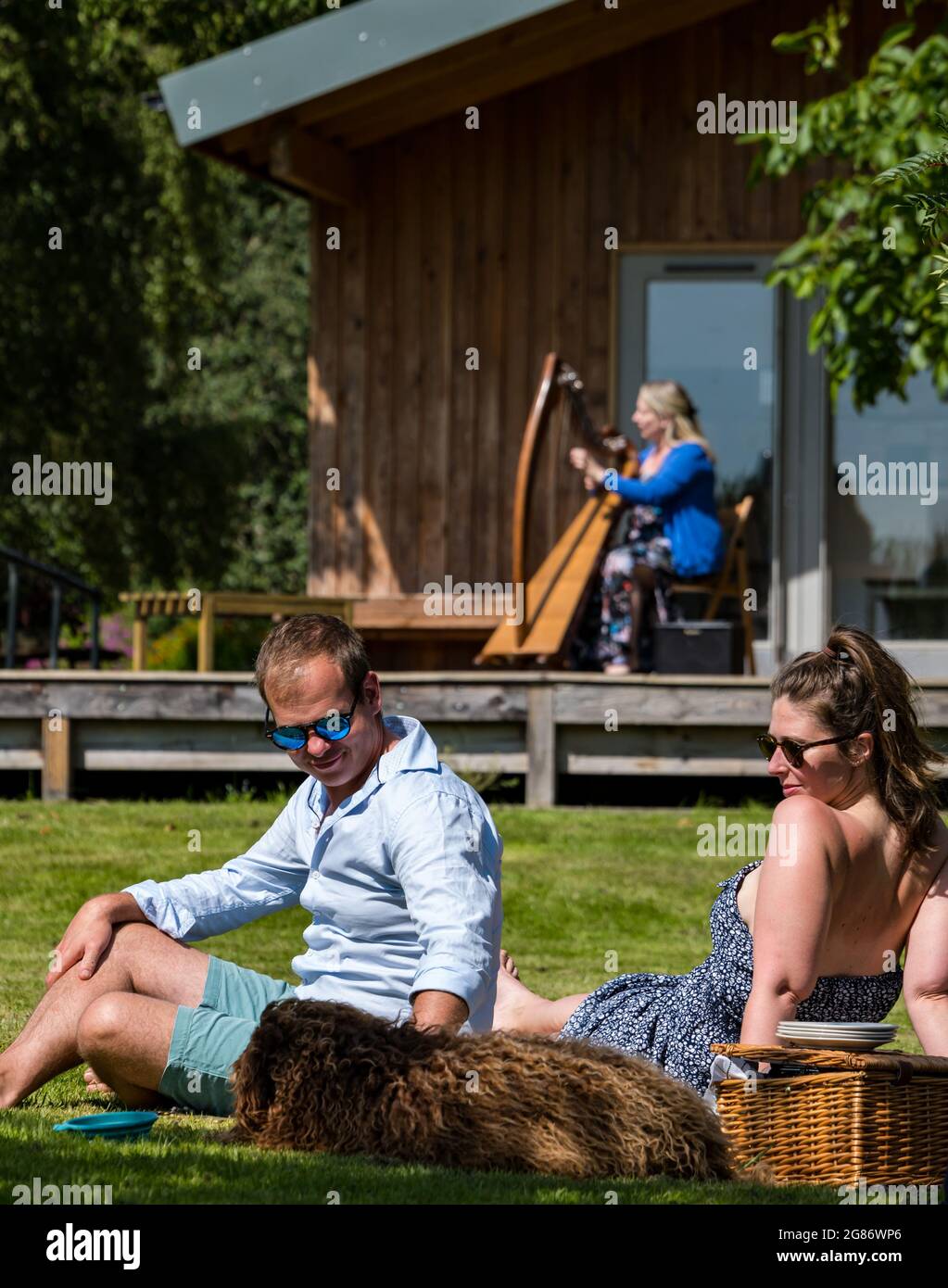 Haddington, East Lothian, Scozia, Regno Unito, 17 luglio 2021. L'arpista celtica Ailie Robertson suona nel giardino murato di Amisfield: Un concerto socialmente distanziato si svolge nel giardino murato gestito da volontari, uno dei più grandi della Scozia. Ailie Robertson è un premiato compositore e performer che suona musica tradizionale e contemporanea arpa Foto Stock