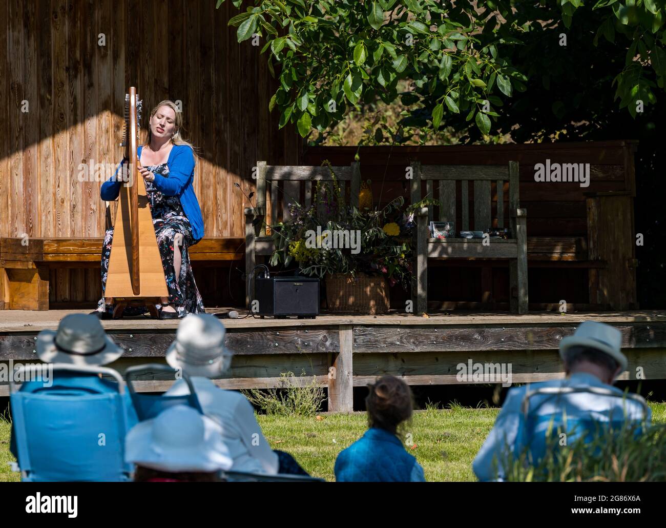 Haddington, East Lothian, Scozia, Regno Unito, 17 luglio 2021. L'arpista celtica Ailie Robertson suona nel giardino murato di Amisfield: Un concerto socialmente distanziato si svolge nel giardino murato gestito da volontari, uno dei più grandi della Scozia. Ailie Robertson è un premiato compositore e performer che suona musica tradizionale e contemporanea arpa Foto Stock