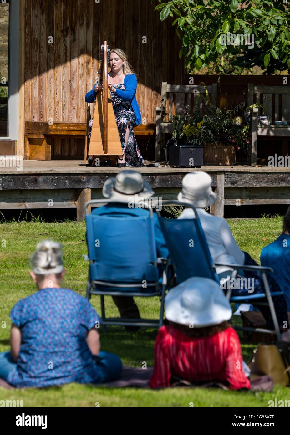 Haddington, East Lothian, Scozia, Regno Unito, 17 luglio 2021. L'arpista celtica Ailie Robertson suona nel giardino murato di Amisfield: Un concerto socialmente distanziato si svolge nel giardino murato gestito da volontari, uno dei più grandi della Scozia. Ailie Robertson è un premiato compositore e performer che suona musica tradizionale e contemporanea arpa Foto Stock