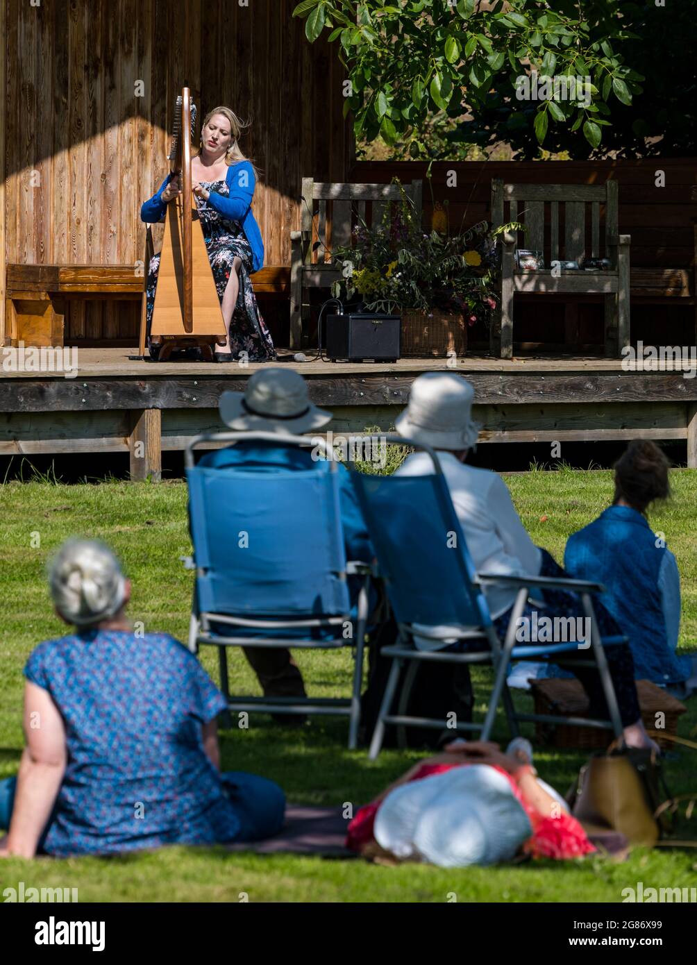 Haddington, East Lothian, Scozia, Regno Unito, 17 luglio 2021. L'arpista celtica Ailie Robertson suona nel giardino murato di Amisfield: Un concerto socialmente distanziato si svolge nel giardino murato gestito da volontari, uno dei più grandi della Scozia. Ailie Robertson è un premiato compositore e performer che suona musica tradizionale e contemporanea arpa Foto Stock