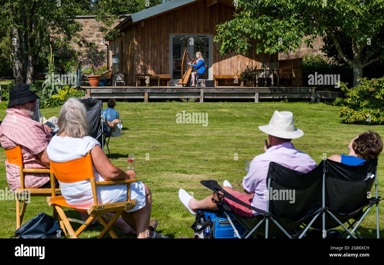 Haddington, East Lothian, Scozia, Regno Unito, 17 luglio 2021. L'arpista celtica Ailie Robertson suona nel giardino murato di Amisfield: Un concerto socialmente distanziato si svolge nel giardino murato gestito da volontari, uno dei più grandi della Scozia. Ailie Robertson è un premiato compositore e performer che suona musica tradizionale e contemporanea arpa Foto Stock